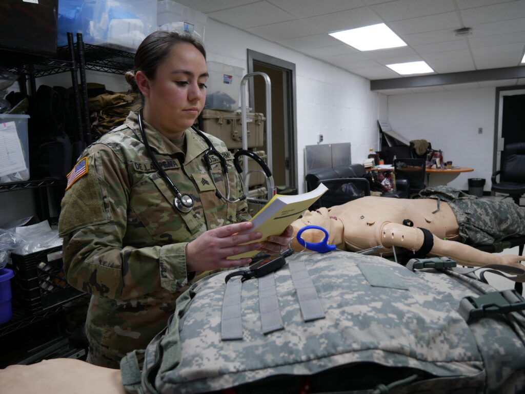 a person in a military uniform and a stethoscope looking at a book.