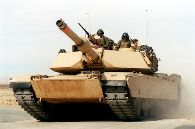 a group of soldiers riding on top of a tank.