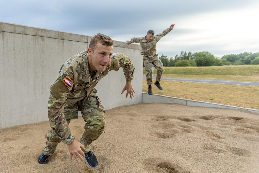 Two soldiers in training on the field.